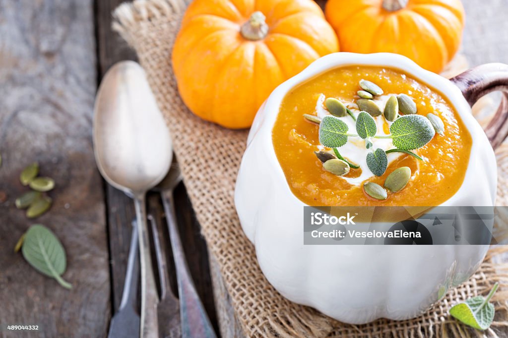 Pumpkin soup with cream, herbs and seeds Pumpkin soup with sour cream, herbs and seeds 2015 Stock Photo