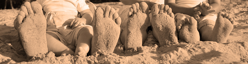 Family with sandy feet at the beach.