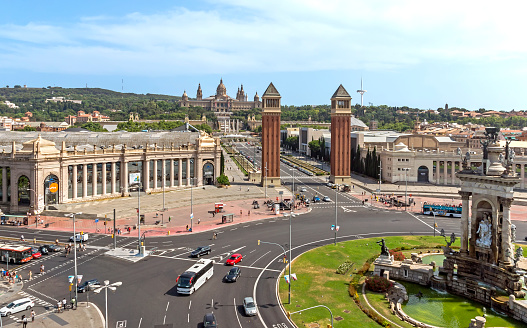 Barcelona, Spain - July 8, 2015: View top to The Placa d'Espanya in Barcelona. Placa d'Espanya fountain and the Fira de Barcelona conference center and Venetian Towers in the foreground, and the MNAC or National Palace and Torre Calatrava in the background, Barcelona, Spain.