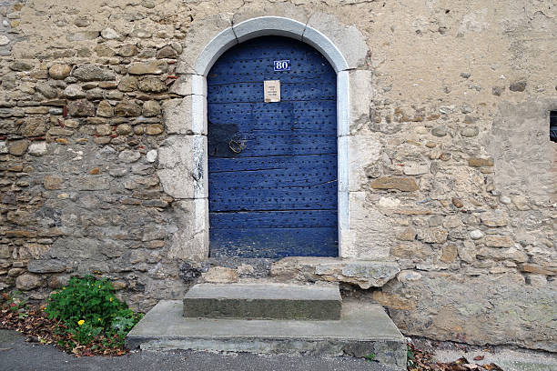 Studded door of an old cloister in a small village of Bugey.