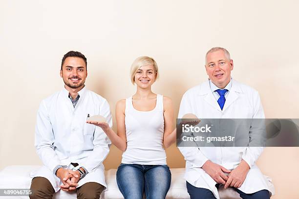 Doctor With Patient Woman Show Breast Implant Plastic Surgery Clinic Stock Photo - Download Image Now