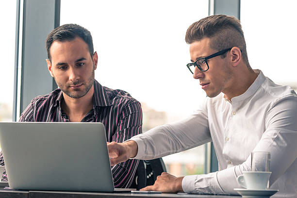istock Two young businessmen making conference call on laptop in office 489080188