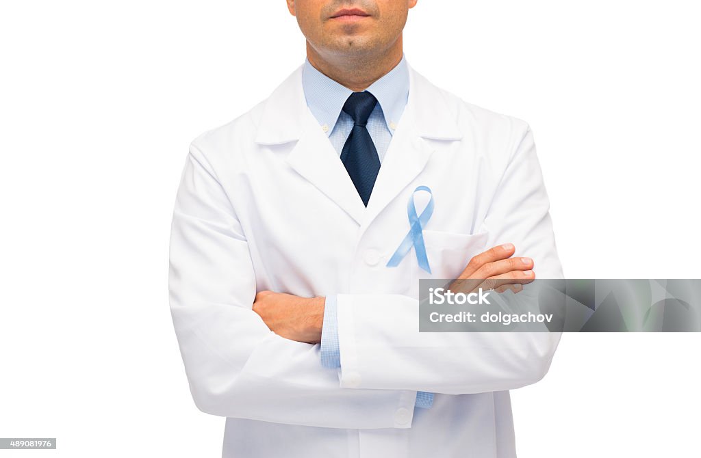 doctor with prostate cancer awareness ribbon healthcare, profession, people and medicine concept - close up of male doctor in white coat with sky blue prostate cancer awareness ribbon Doctor Stock Photo