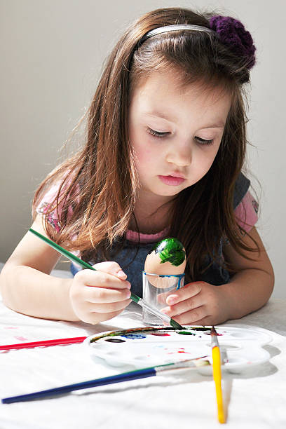 istock Little girl coloring easter eggs 489082235