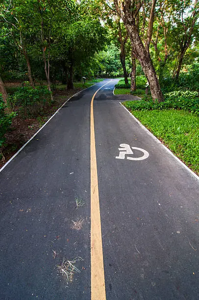 Photo of Road way cyclists and wheelchair in the garden,Thailand