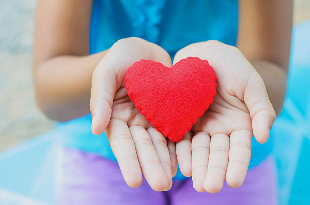 istock red heart on hand little girl 489083353
