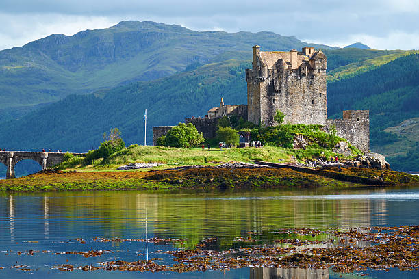 Eilean Donan In The Afternoon Sun Dornie, Scotland - August 3, 2015: Afternoon sunlight falls upon the iconic form of Eileen Donan Castle in Scotland. The waters of Loch Duich stretch away into the distance. scottish highlands castle stock pictures, royalty-free photos & images