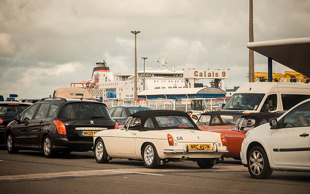 Cars boarding the ferry at Calais Calais, France - September 1, 2015: Cars queuing to board ferries heading England at Calais port. Now port's security is even more busy controlling the flood of illegal migrants who try to reach Britain. ferry dover england calais france uk stock pictures, royalty-free photos & images