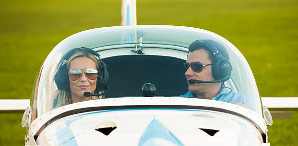 Woman and man pilot looking at camera, preparing for flying