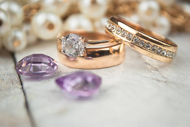 istock Golden wedding rings on white wood background 489089898