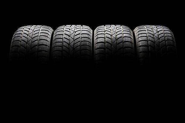 istock Set of four black car tires lined up horizontally 489090066