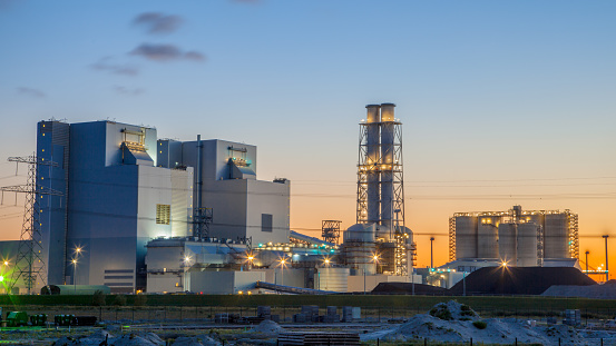 Ultra modern coal powered electrical power plant during sunset under a blue and orange sky