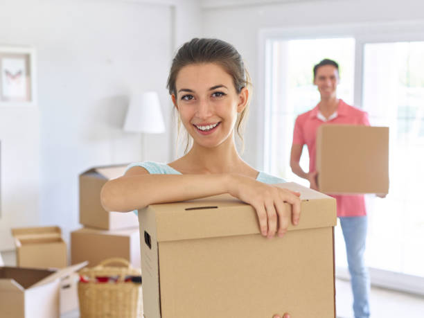 istock Couple carrying cardboard boxes and smiling 489114996