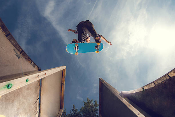 in basso vista di un giovane skateboard in gradino posizione. - ollie foto e immagini stock