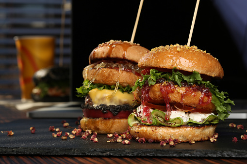 Huge Double hamburger with fresh grilled beef isolated on a black background with pistachios