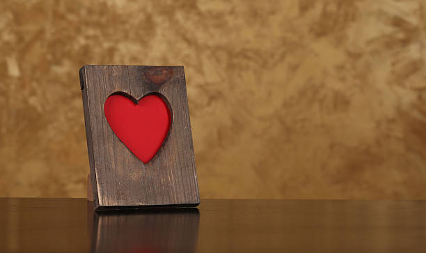 istock Wooden frame with a red heart symbol on the table 489118508