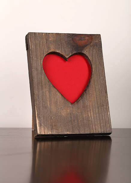 istock Wooden frame with a red heart symbol on the table 489118960