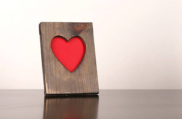 istock Wooden frame with a red heart symbol on the table 489118978