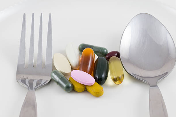 istock Multiple drug pills on a plate, spoon and fork. 489119271