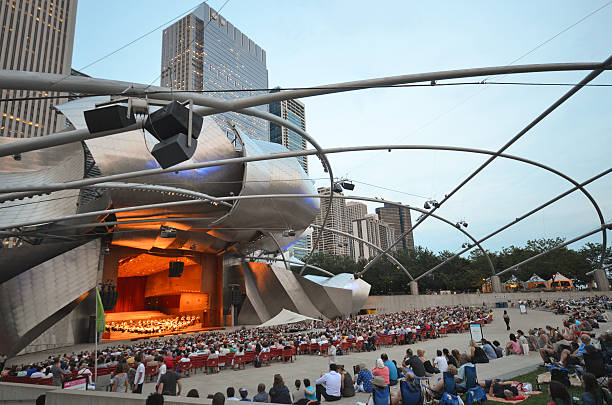 Chicago Concert Сhicago, USA - August 14, 2015: A concert performance at the Jay Pritzker Pavilion in Chicago - the Pavilion, designed by Frank Gehry, is an outdoor performing arts venue. grant park stock pictures, royalty-free photos & images
