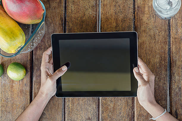 istock woman hands on digital tablet on wooden table 489119942