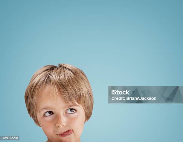 Boy Looking Up With Tongue Out Licking His Lips Stock Photo - Download Image Now - Child, Hungry, Licking Lips