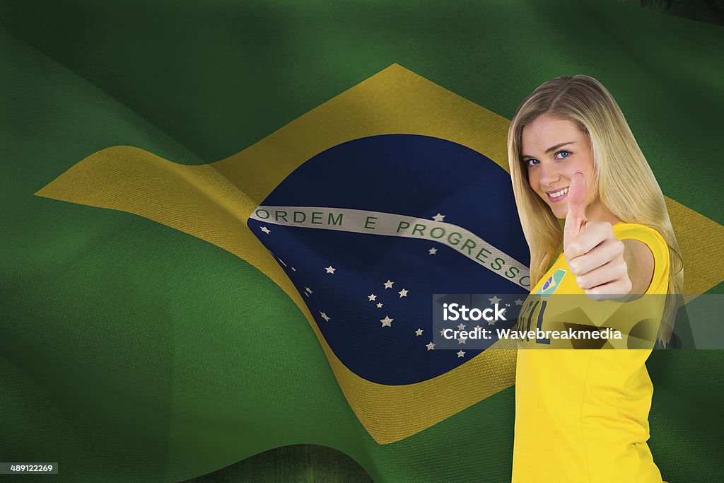 Pretty football fan in brasil tshirt Pretty football fan in brasil tshirt against digitally generated brazil national flag 18-19 Years Stock Photo