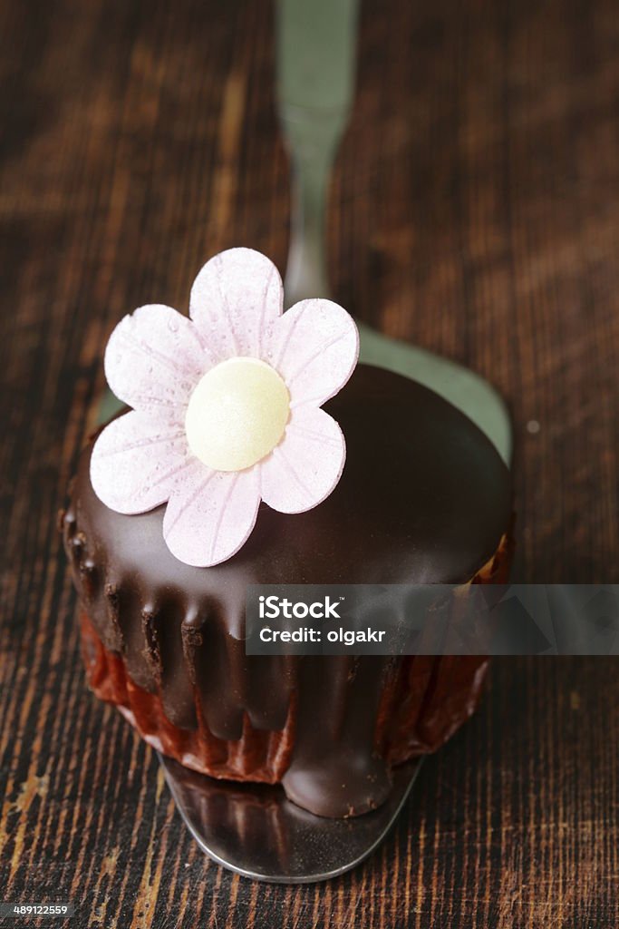 sweet cupcake with chocolate icing on a wooden background Baked Stock Photo