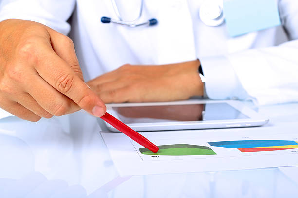 istock Doctor  in a white labcoat showing something on a graphs 489122746