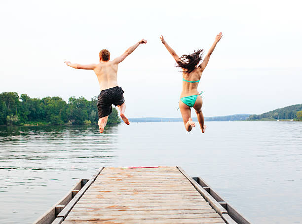 istock Good friends jumping into the lake 489122973
