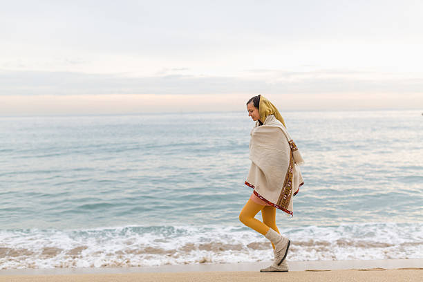 istock Young woman walking on the beach during sunrise 489123604