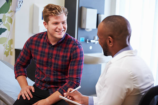 male patient and doctor have consultation in hospital room - 耐性 個照片及圖片檔