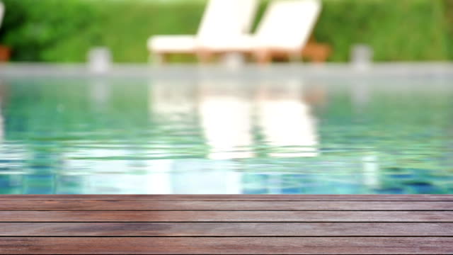 Wood plank on rippled swimming pool water background