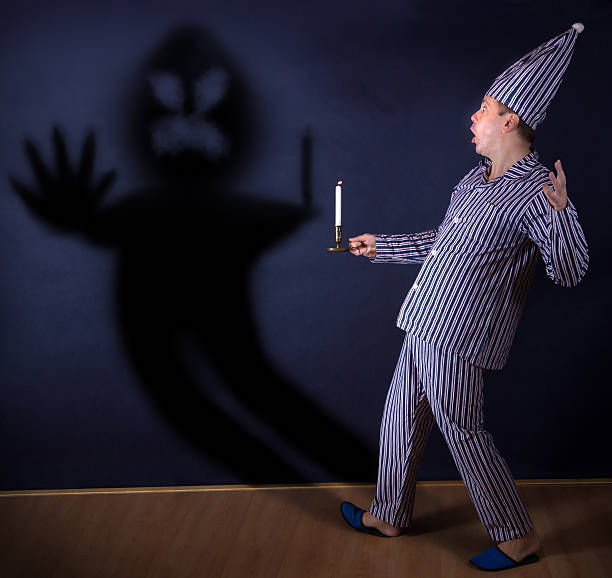 homem com vela em pijama - paranoia terrified men horror - fotografias e filmes do acervo