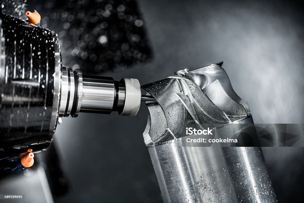 Metalworking CNC milling machine. Metalworking CNC milling machine. Cutting metal modern processing technology. Small depth of field. Warning - authentic shooting in challenging conditions. A little bit grain and maybe blurred. CNC Machine Stock Photo