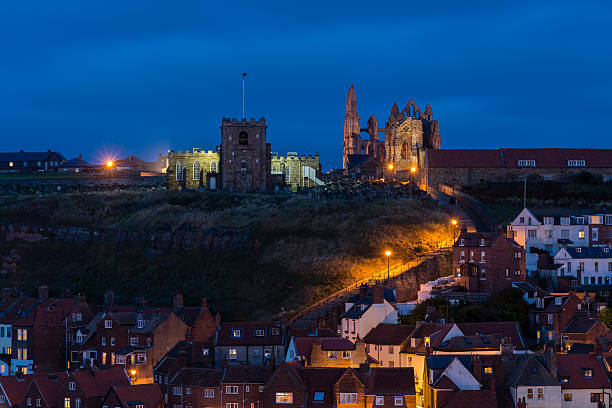 Whitby, England - August 11, 2015: Whitby beach, church, town and abbey in North Yorkshire, England. Picturesque fishing town with distant people.