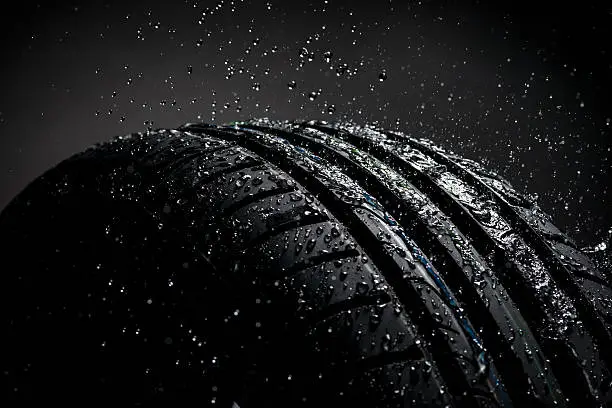 Photo of Water splashing on tire during the rain, side view