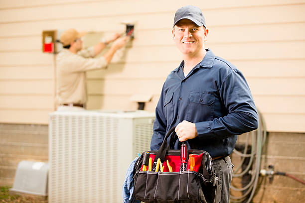 istock Air conditioner repairmen work on home unit. Blue collar workers. 489144870
