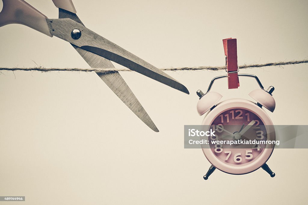deadline hand cutting a rope with a clock hung on by a wooden clip - importance of time 2015 Stock Photo