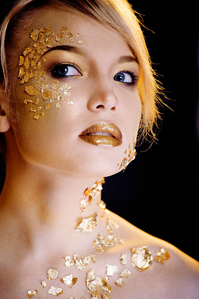istock beauty blond woman with gold creative make up 489146134
