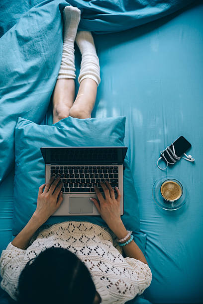 chica en cama con la computadora portátil - working bed smart phone bedroom fotografías e imágenes de stock