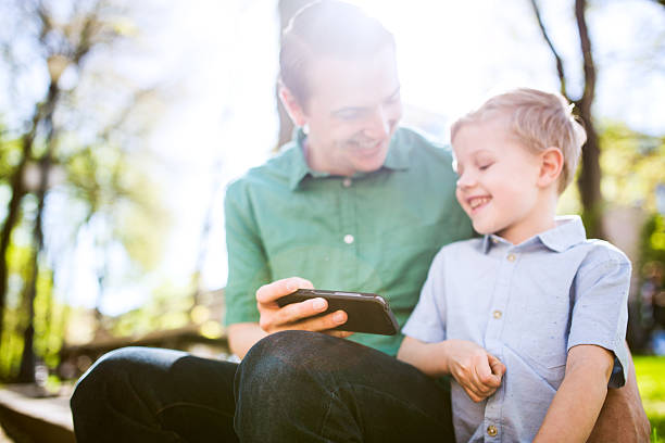 istock Dad and Son on Smart Phone 489168580