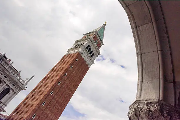 Picture of the Campanile in St.Marks square, framed by one of the arches of the Basilica di San Marco