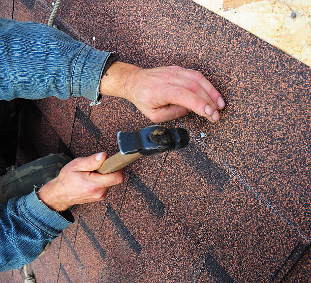 istock Roofer installs bitumen roof shingles 489169932