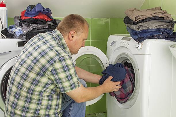 istock man washes clothes in the washing machine 489170886