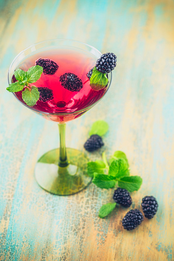 Martini cocktail drink with blackberries and mint