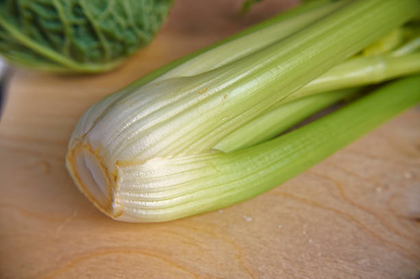 Green fresh stem of celery closeup on wooden table