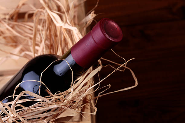 One luxury full dark glass bottle of red expensive collection grape wine in gift wooden box with straw, horizontal photo