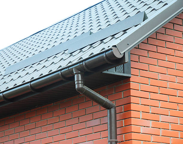 Closeup on rain gutter system and roof snow protection Closeup on new rain gutter system and roof protection from snow board (Snow guard) on house construction steel gutters stock pictures, royalty-free photos & images