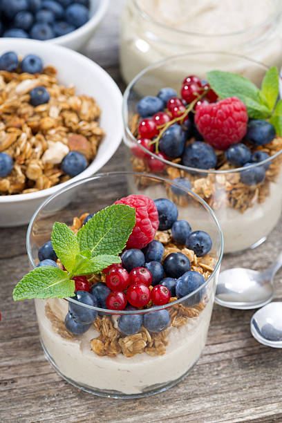 istock dessert with sweet cream, fresh berries and granola, vertical 489179236